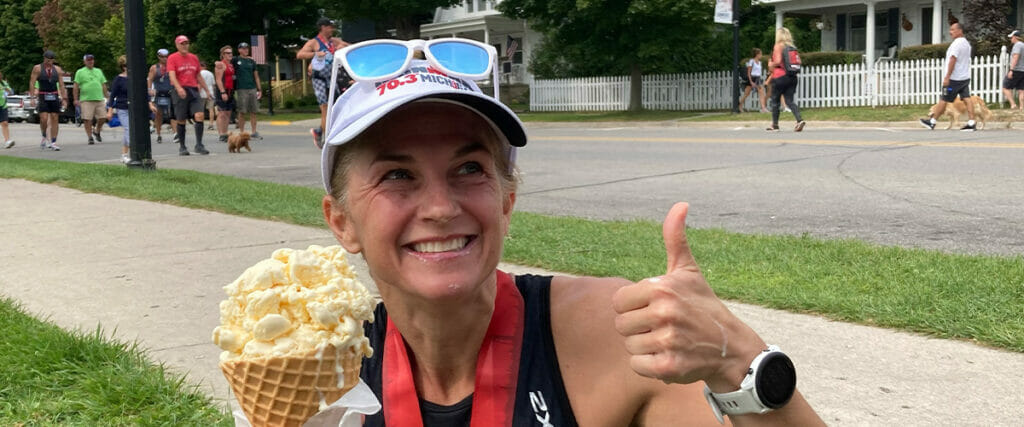 Angie eating ice cream after a race with a thumbs up