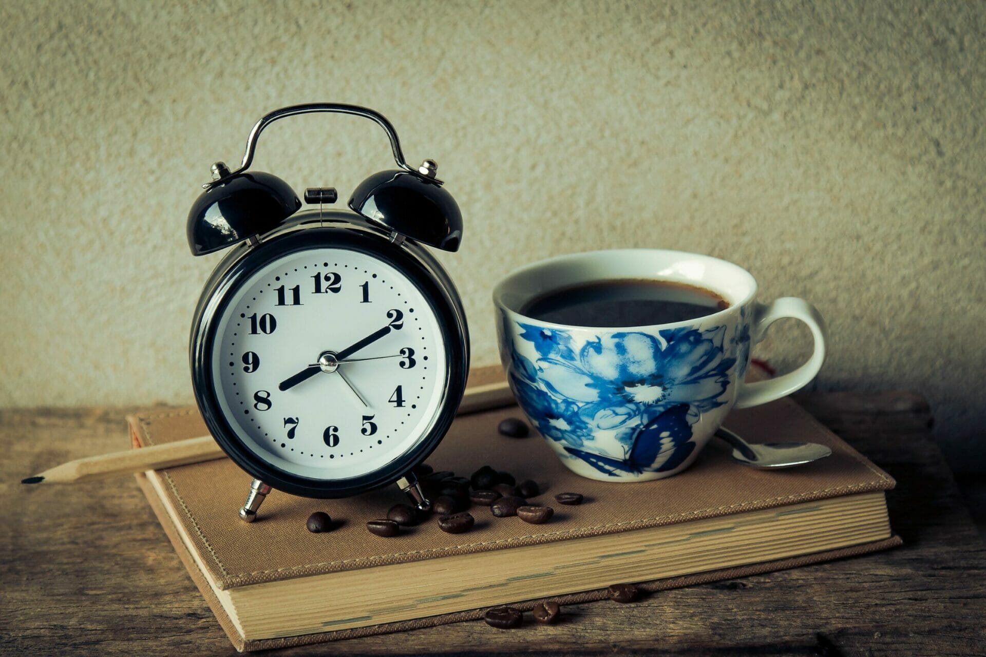 Clock with a cup of coffee next to it - The World is Waking Up