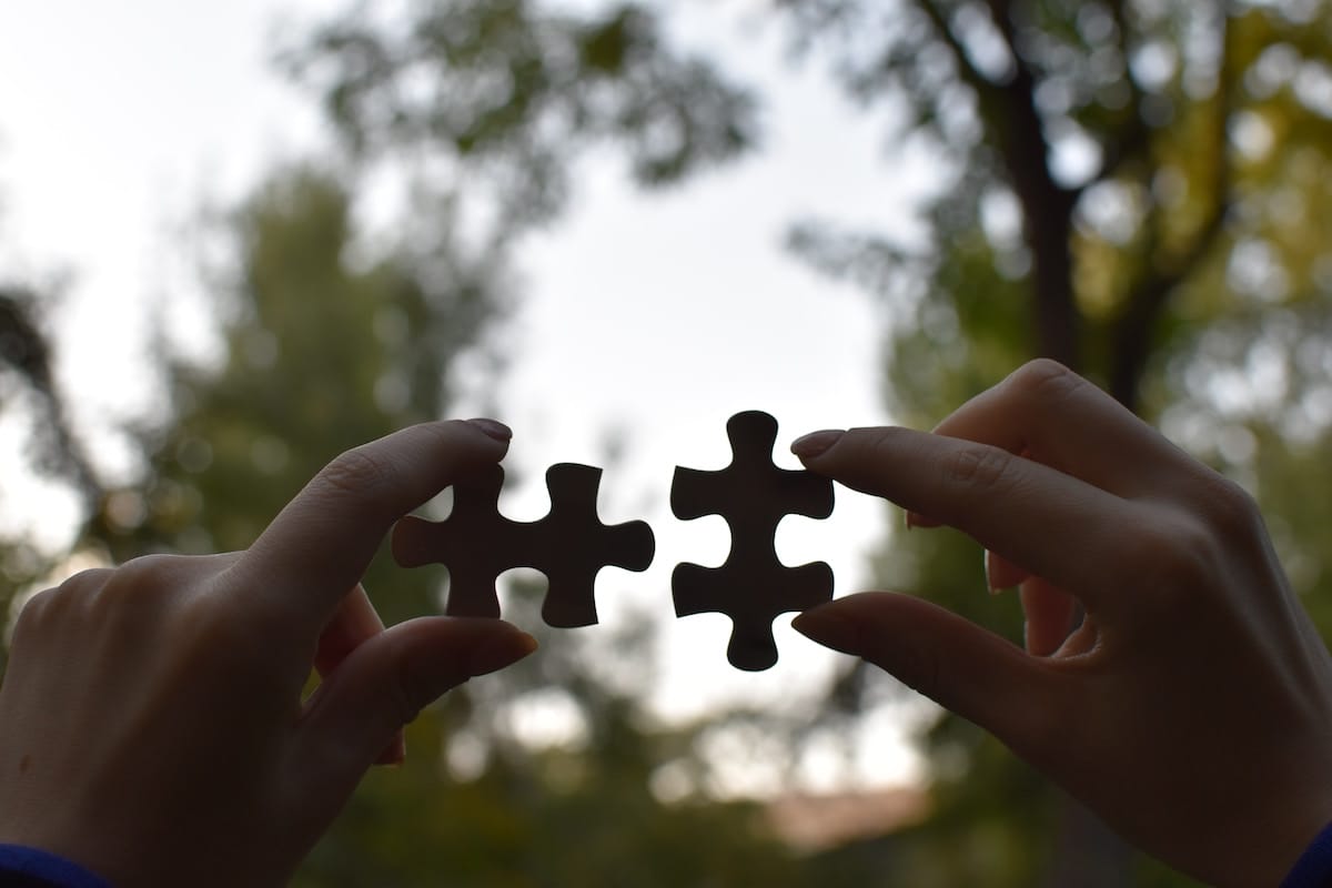 hands-holding-two-pieces-of-a-jigsaw-puzzle