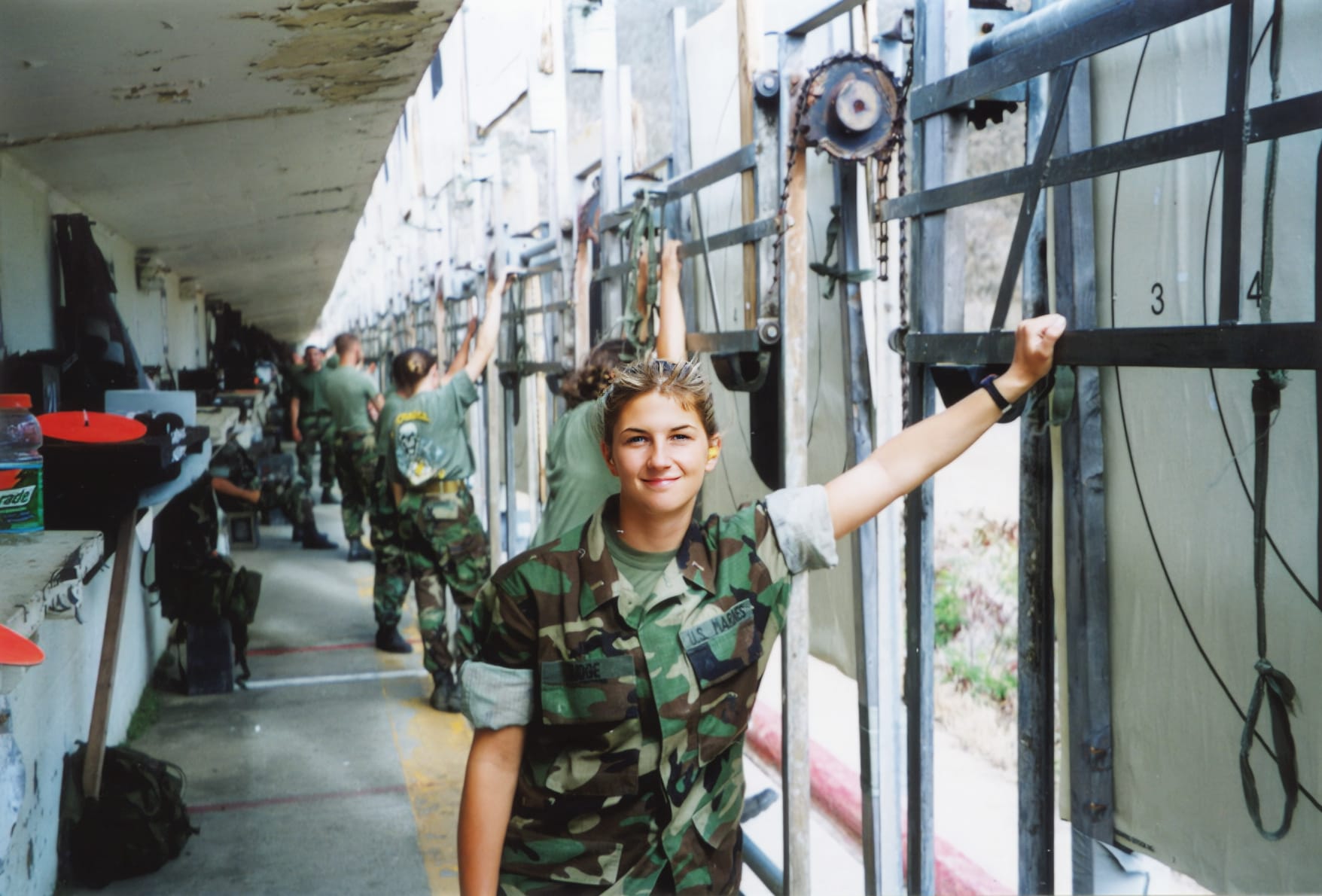 Angie leaning against a wall in her military uniform
