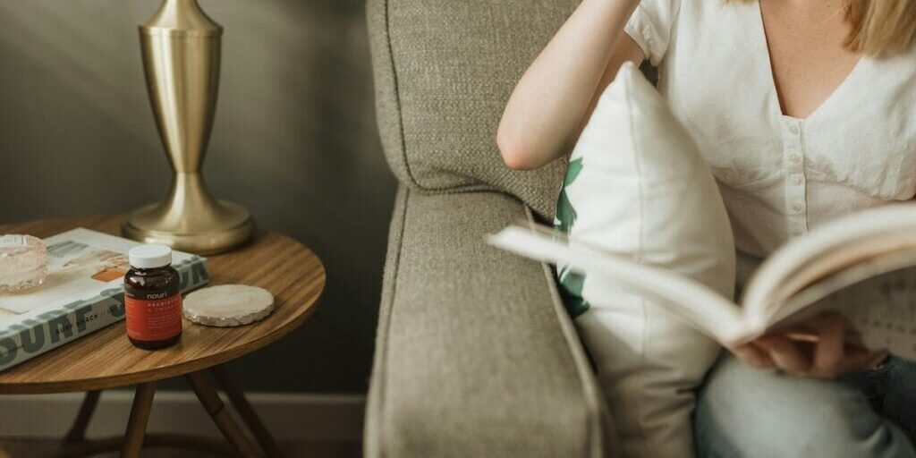 Woman holding a book and sitting on her couch