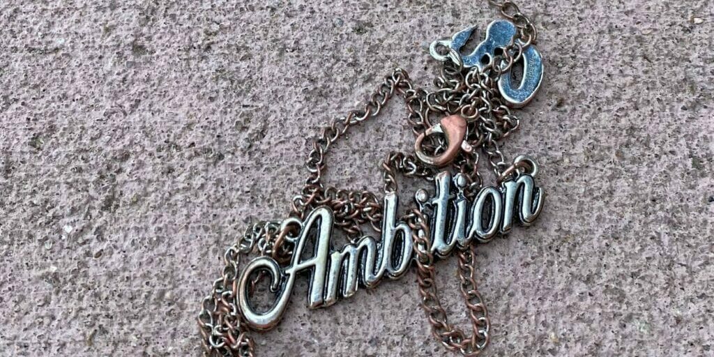 battered necklace that says Ambition - Differing Ambitions? Some Things Are Universal.