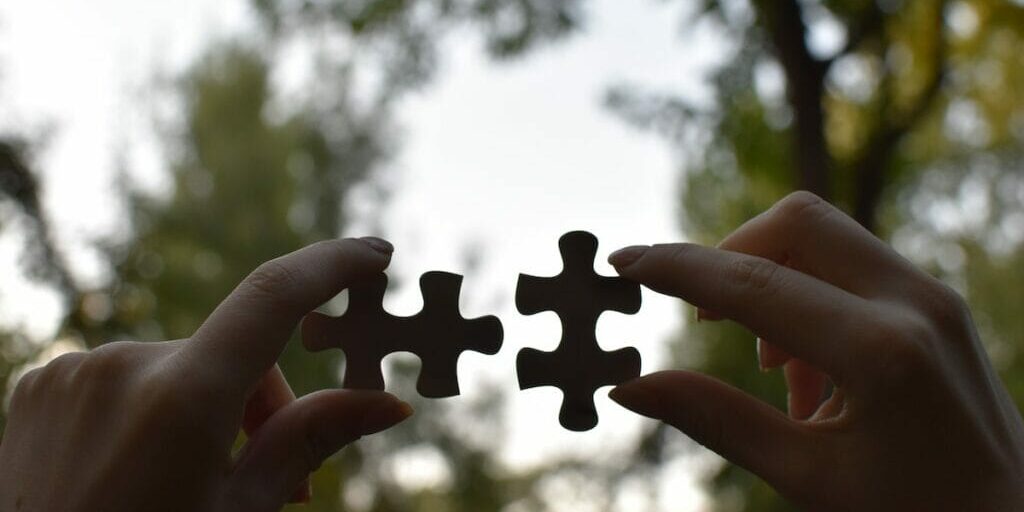 hands-holding-two-pieces-of-a-jigsaw-puzzle
